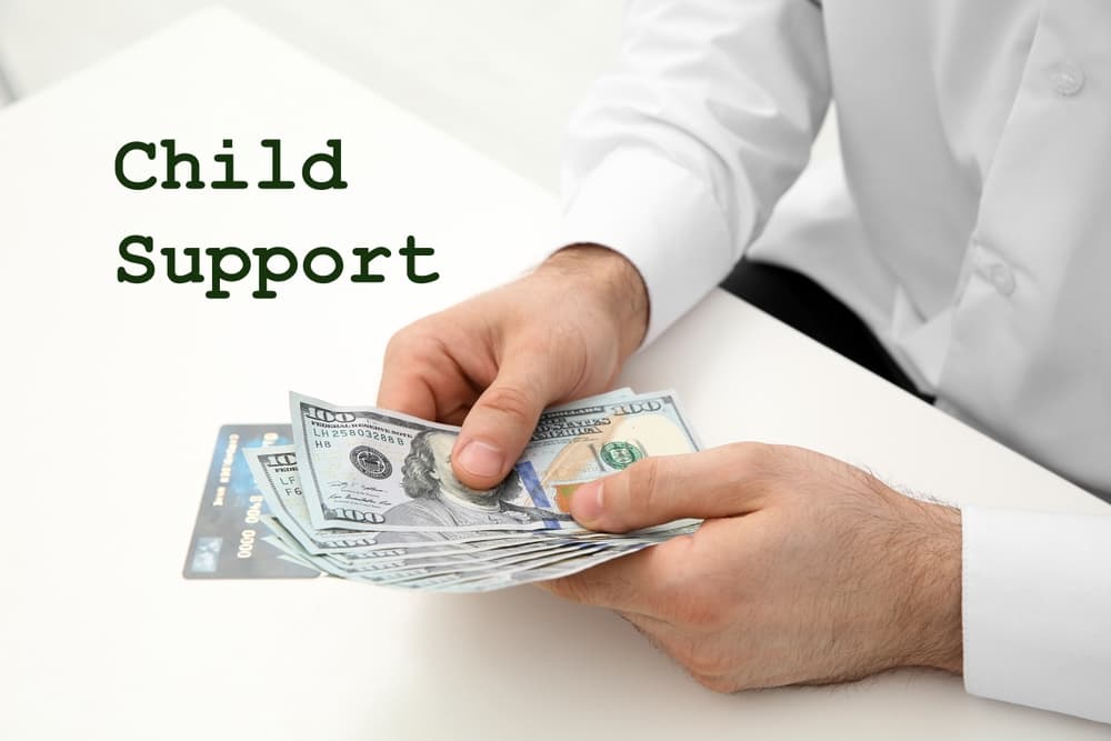 Child support concept. Man with money at white table indoors, closeup