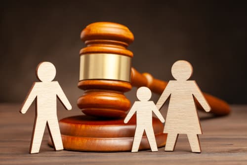 gavel on desk with mother child and father wooden shapes