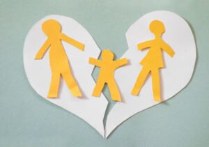 Paper cutout family split apart on a paper heart