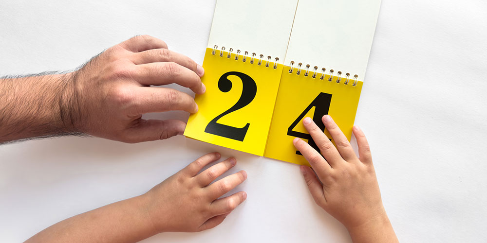 Parent and child reviewing a calendar concept image, representing parenting schedules, visitation, and custody agreements for Barrington fathers