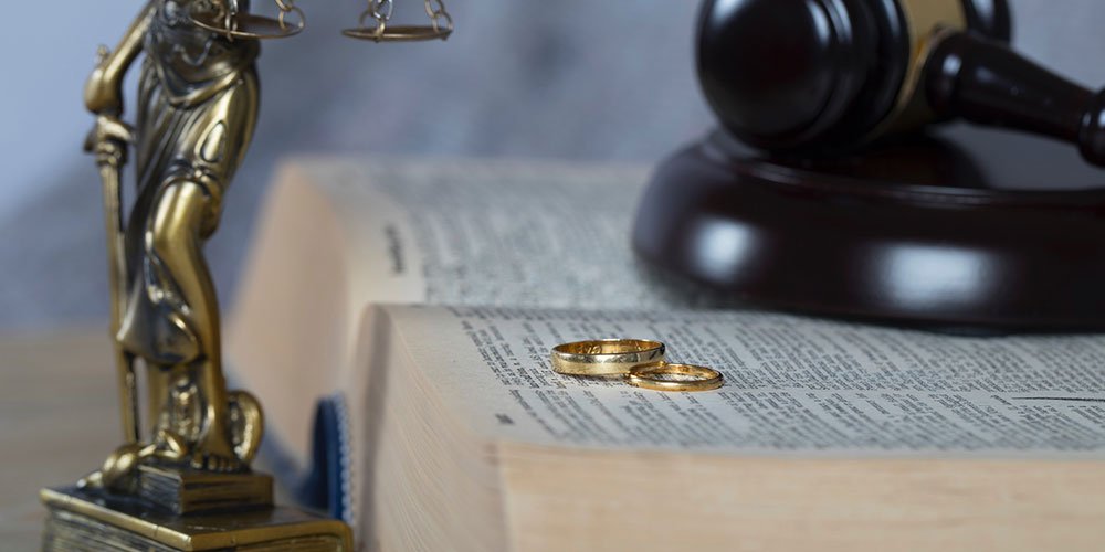 Marriage rings on a law book concept image, representing asset protection and high net worth divorce counsel in Barrington, Illinois